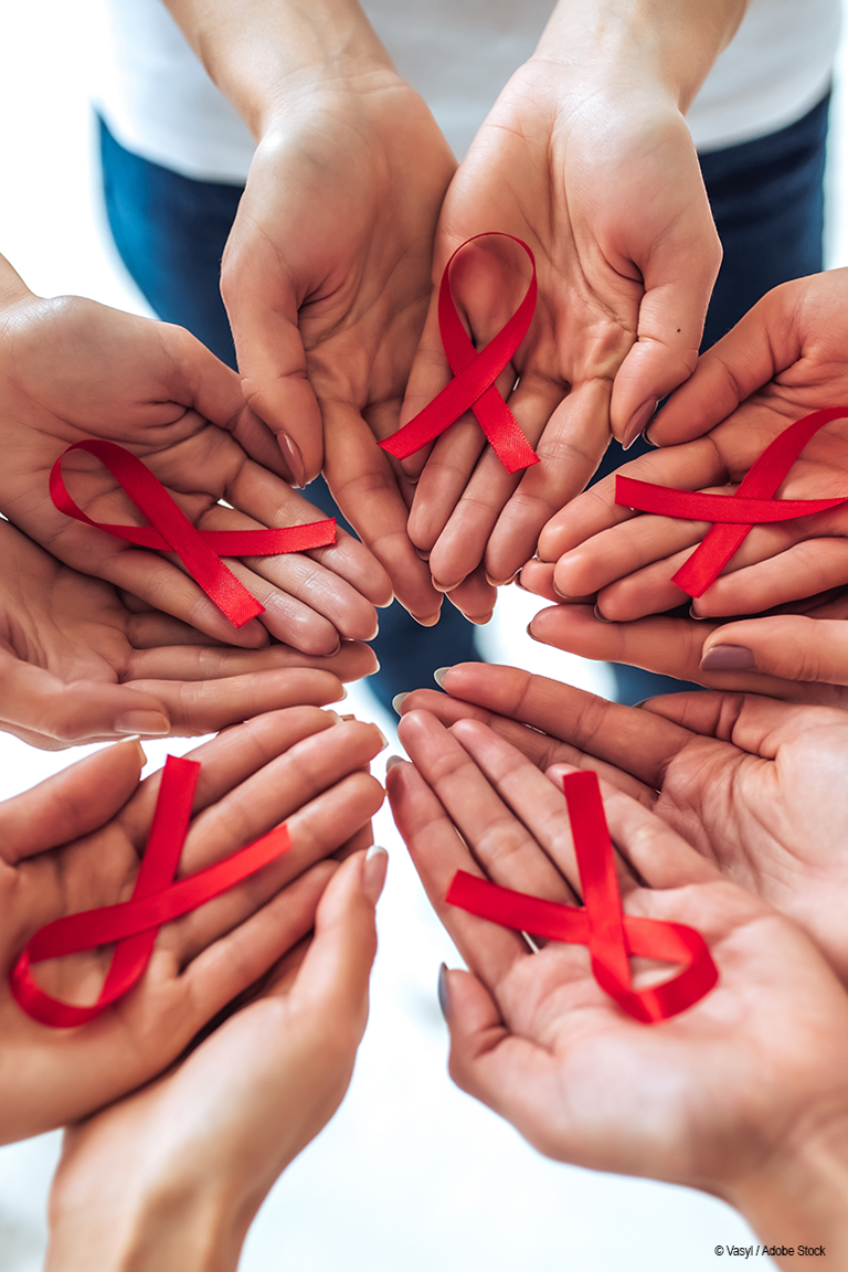 Mehrere Handinnenflächen bilden einen Kreis und in jeder Hand liegt eine rote Aidsschleife